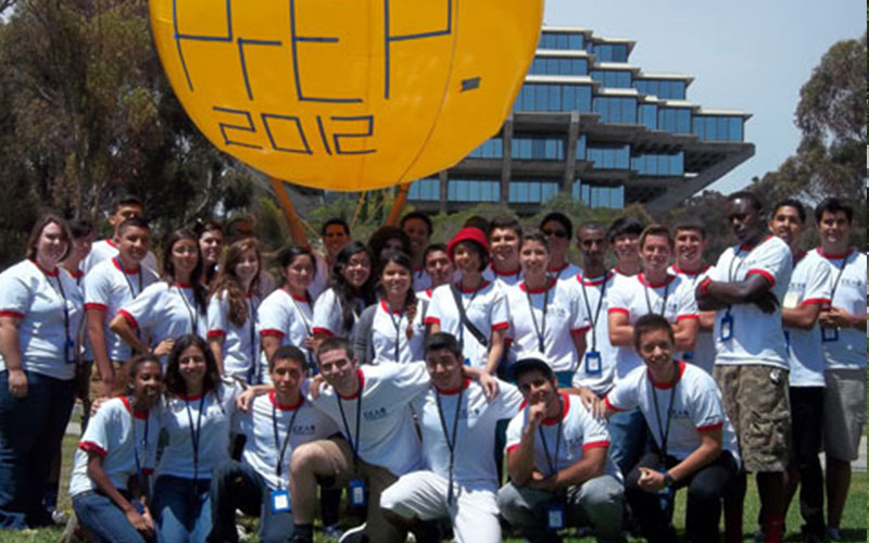 Students standing and squatting for photo in front of Geisel Library