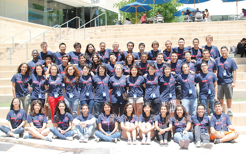 Students sitting and standing in front of steps for photo