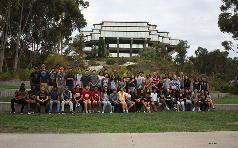 Students sitting and standing with Geisel Library in background for photo