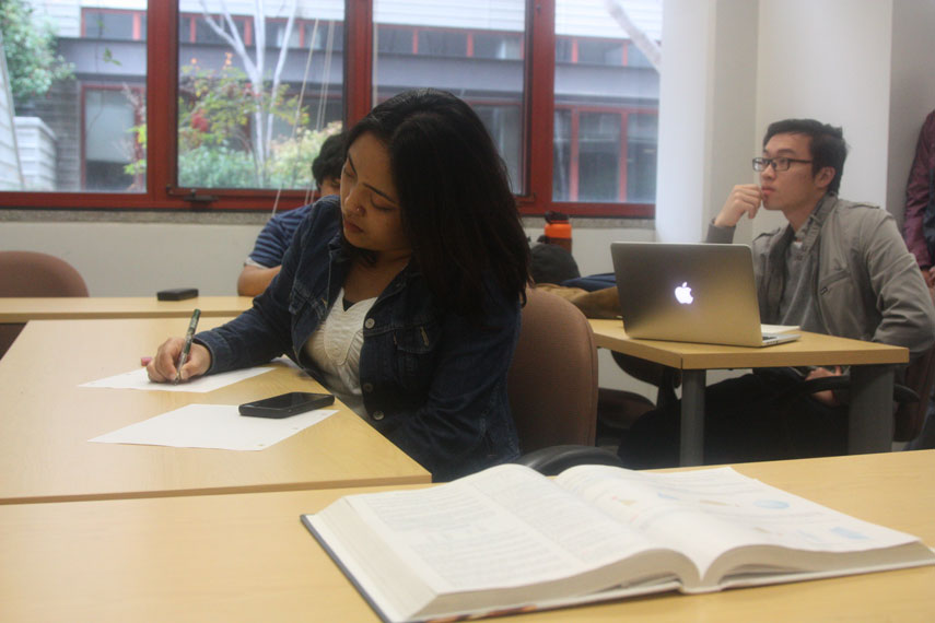 Student sitting and writing on a piece of paper