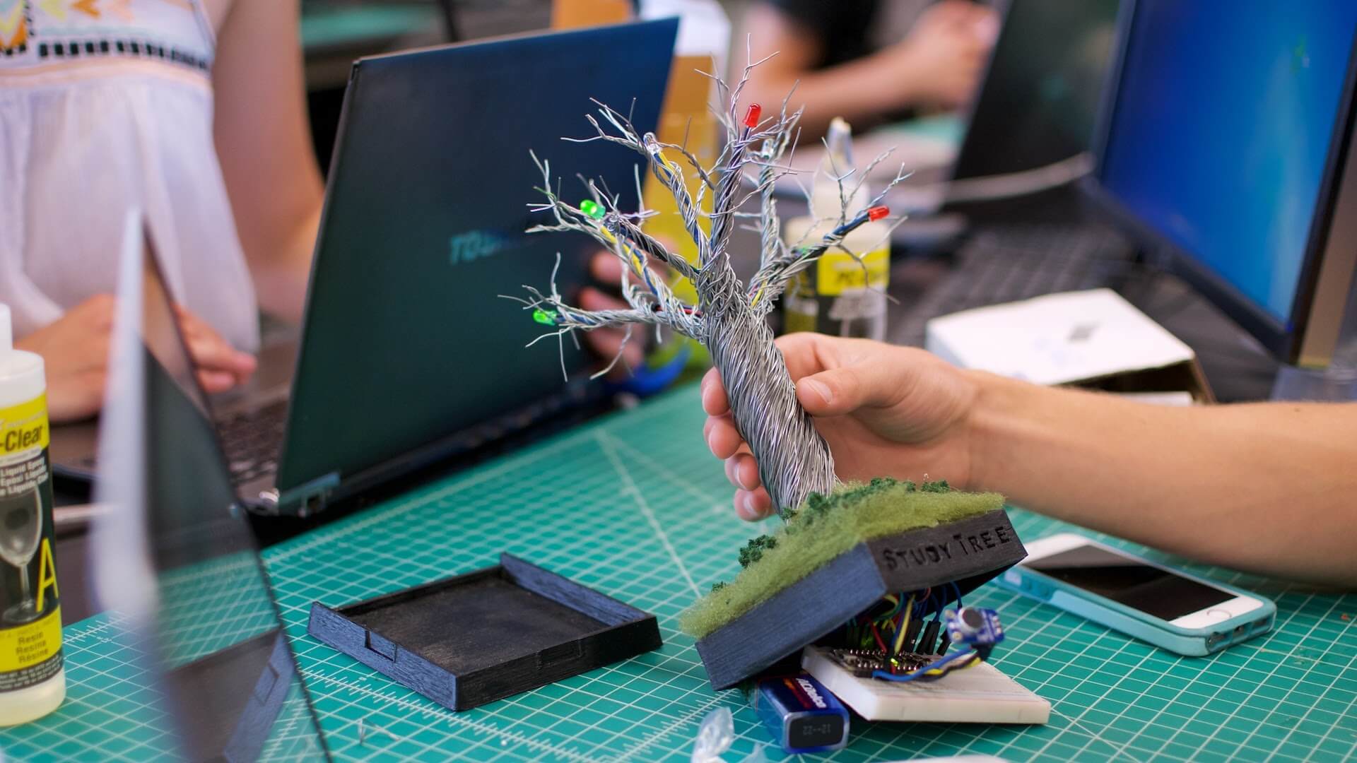 Student holding electronic device that looks like a tree