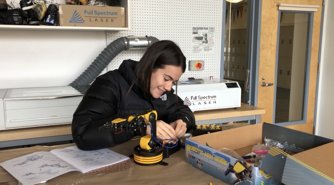 Sophie Cohen works on a robotic arm in the classroom.